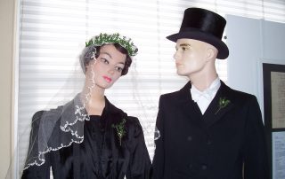 Zwei Schaufensterpuppen im Hochzeitsoutfit, Braut mit Schleier und Bräutigam.