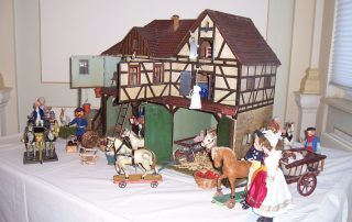 Miniaturmodell eines Fachwerkhauses mit Figuren und Tieren im ländlichen Stil.