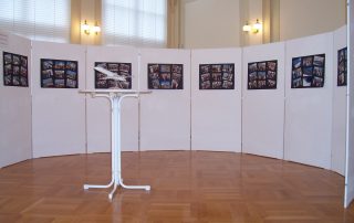 Ausstellungsraum mit Flugzeugmodell und Fotowänden auf Holzboden.